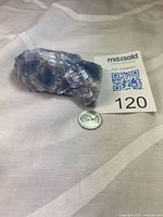 Blue calcite specimen beside coin for scale