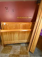 Headboard and footboard standing upright showing sleigh profile and plank construction