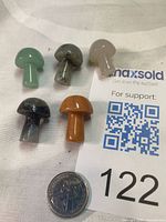 Five gemstone mushrooms with coin for scale and auction tag