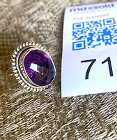 Front view of sterling silver ring with faceted oval amethyst stone