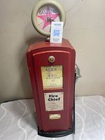 Full view of red wooden gas pump cupboard with Fire Chief panel and clock