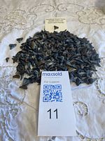 Pile of numerous small fossilized shark teeth with reference cards