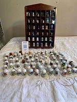 Front view of display case filled with thimbles and additional thimbles arranged on table
