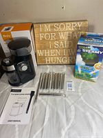 All items laid out: grinder, box, sign, dryer balls, straws