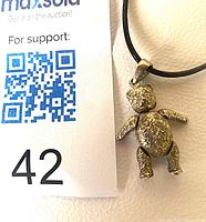 Full view of sterling silver teddy bear pendant on black cord