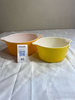 Two coloured Pyrex casseroles side by side