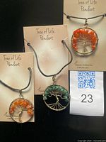 Group shot of three Tree of Life gemstone pendants on backing cards plus lot tag