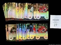 Two stacks of holographic hockey cards showing fronts of various players, approximately 100 cards