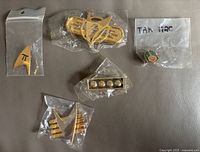 Front view of all five sealed Star Trek metal badges