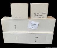 Four cardboard storage boxes containing the card sets, handwritten labels visible