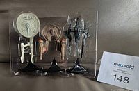 Front view of three miniature starships and three stands in blister tray