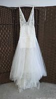 Full frontal view of lace and tulle wedding dress hanging