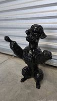 Full view of glossy black ceramic poodle sculpture standing upright