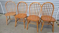 Front view of four matching wooden Windsor spindle-back chairs