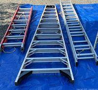 Three ladders laid out: red/orange Keller extension, silver Keller extension, silver ladder