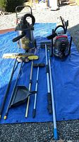 Overall lot on tarp showing both vacuums, broom, poles, dustpan
