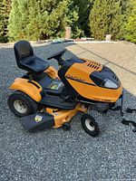 Left side view of Cub Cadet mower showing model branding, seat, deck and tires