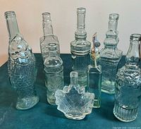 Group of eight assorted clear glass bottles and decanters