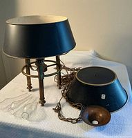 Lamp fixture standing with one shade, extra shade and chimneys visible