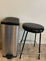 Trash can and stool side by side showing overall form and size