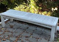 Full view of teak bench on patio