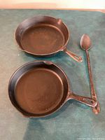 Top view two cast iron skillets and spoon
