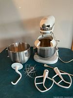 Mixer with both bowls and all four attachments displayed