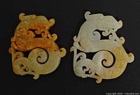 Front view of both jade plaques showing dragon carvings and color variation