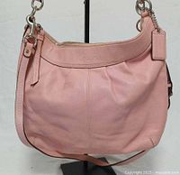 Front view of pink Coach Soho leather hobo handbag on stand