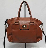 Front view showing satchel shape, front flap pocket, handles, strap