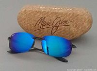 Sunglasses front view with case behind showing Maui Jim logo