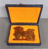 Statue resting in open padded presentation box