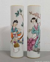 Front view of both cylindrical vases showing handpainted figures and motifs