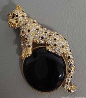 Front view of rhinestone leopard brooch on black cabochon