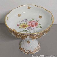 Oblique view showing entire footed dish with floral interior and gold trim