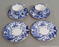 Two cups on saucers with two additional plates