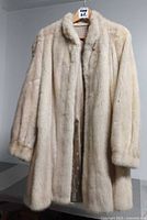 Front view of cream mink fur coat on hanger