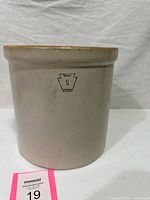 Front view of stoneware crock showing maker stamp