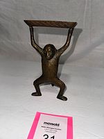 Front view of standing monkey figure holding tray