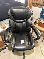 Front view of black high-back office chair showing seat, backrest, armrests, upholstery and stitching