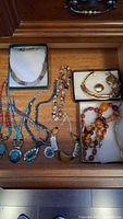 Drawer view of necklaces, collar, bracelets in boxes