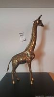 Profile view of brass giraffe figurine on tabletop