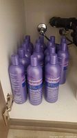 Cluster of purple Shimmer Lights shampoo bottles stored in cabinet