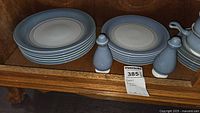Dinner and salad plate stacks, salt & pepper shakers, additional serving piece visible