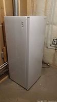 Full front-left view of white Insignia upright freezer