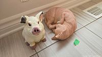Pig and cat figurines on tiled floor