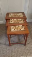 three wood nesting tables stacked showing tile tops