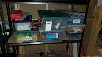 Overall view of shelving showing three labelled totes and surrounding items