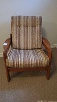 Front view of wood-framed lounge armchair with striped cushions