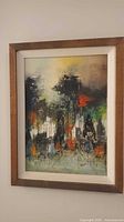 Full view of framed abstract cityscape painting on wall